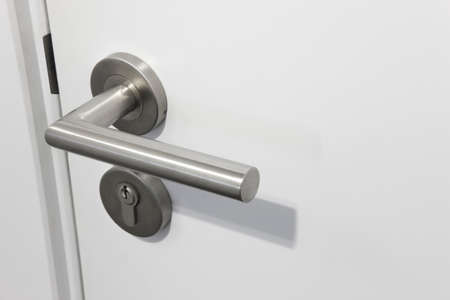 Metallic doorknob with lock over a white door. Horizontalの写真素材