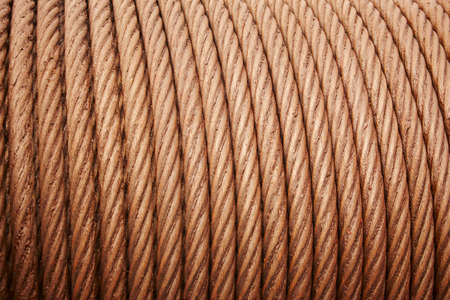 Heavy steel coiled greased cable detail in warm tone. Horizontal