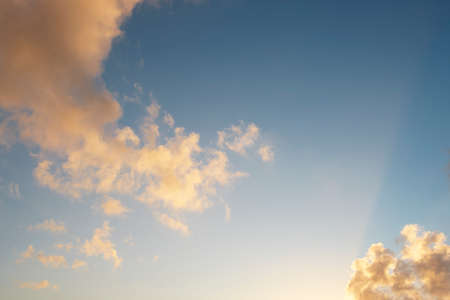 Blue sky with clouds in warm tone at sunset. Horizontal