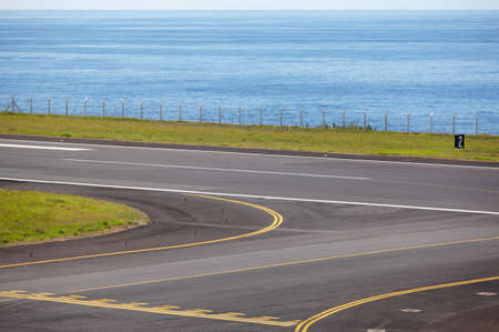 Airport runway close to the ocean with lines and fence. Horizontalの写真素材