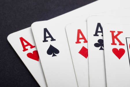 Poker card game with four aces and king. Black background. Horizontal