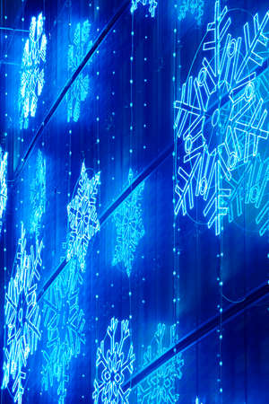 Christmas lights decoration on a building facade in blue tone. Verticalの写真素材