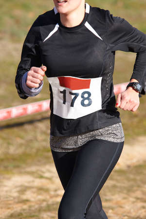 Female athletic runner on a race. Outdoor circuit. Vertical