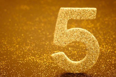 Number five golden color over a warm background. Anniversary. Horizontalの写真素材