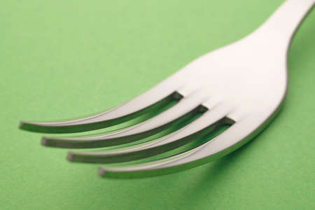 Fork detail over a green background. Cutlery. Horizontal