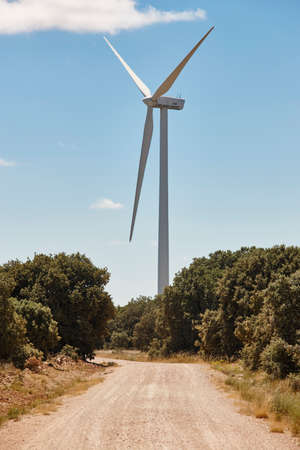 Wind turbine and gravel road. Clean alternative renewable energy. Vertical