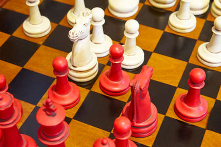 Chess pieces in red and white color over the table. Play game