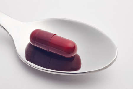 Pills and spoon over a white background. Medicament treatment. Healthcare