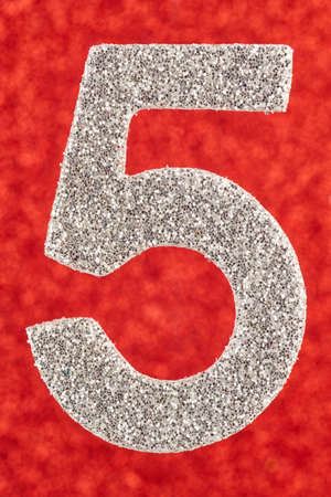 Number five silver color over a red background. Anniversary. Verticalの写真素材