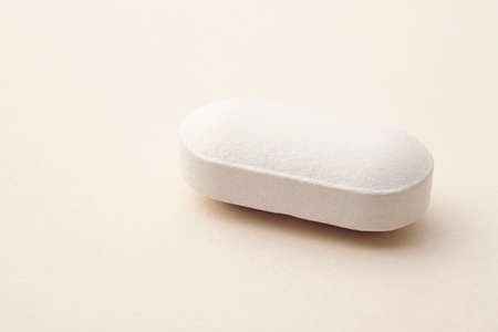 Pill over a beige background. Medicament treatment. Health care photoの写真素材