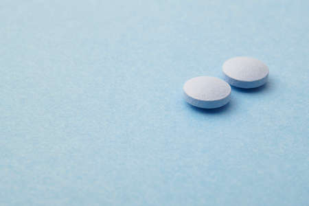 Pills over a blue background. Medicament treatment. Health care photoの写真素材