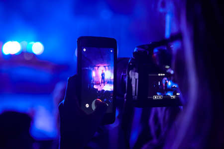 Smartphone camera video photo recording. Live concert by night. Horizontalの写真素材