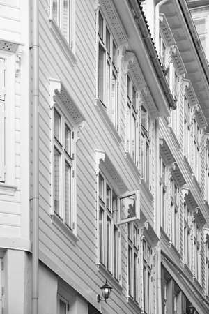Traditional norwegian wooden white facades. Antique street in Bergen. Verticalのeditorial素材