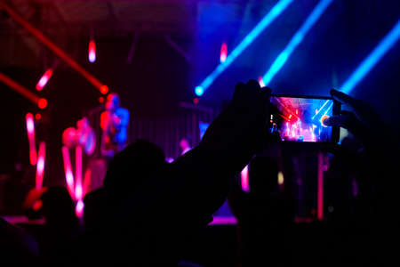 Smartphone video photo recording. Live concert by night. Horizontal