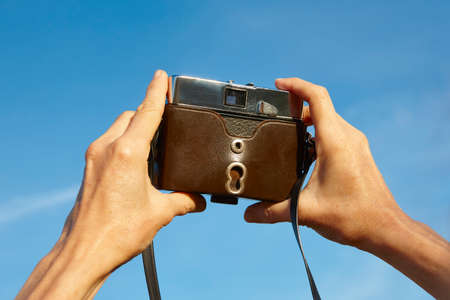 Taking pictures with a vintage film camera. Outdoor photography. Horizontal