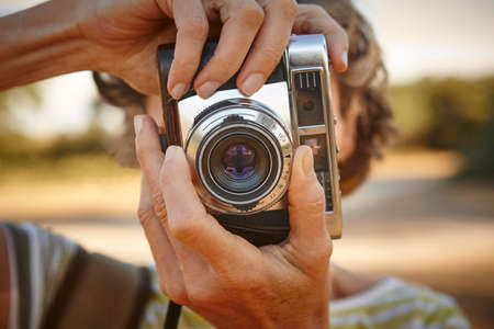 Woman taking pictures with vintage camera. Travel background.