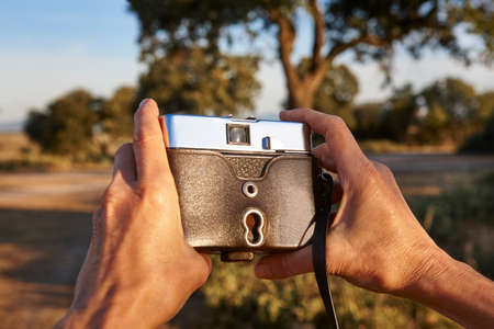 Tourist with vintage camera in the countryside. Travel background. Lifestyleのeditorial素材