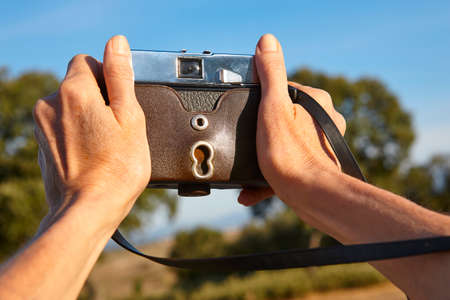 Hands on vintage camera in the countrysideの写真素材
