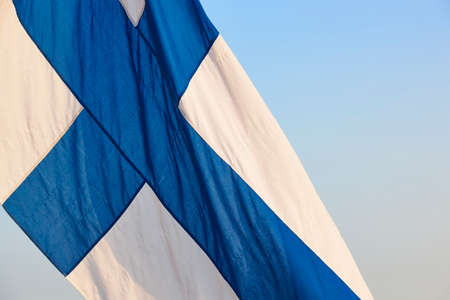 Finnish flag under a blue sky. Finland symbol. Europe. Horizontal