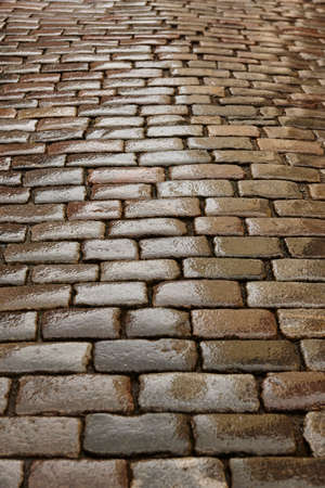 Antique wet cobblestone street at dawn. Vintage background. Verticalの写真素材