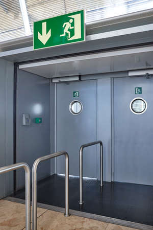 Airport emergency exit way out way metallic doors. Alert sign