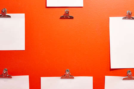 Blank paper sheets on an orange wall. Office material. Informationの写真素材