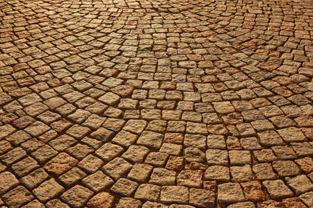 Street paving stone in warm tone. Antique urban sidewalk. Horizontal
