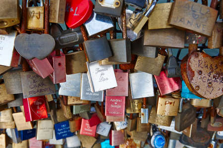 Colored rusted padlocks chained on a bridge handrail. Romantic backgroundのeditorial素材