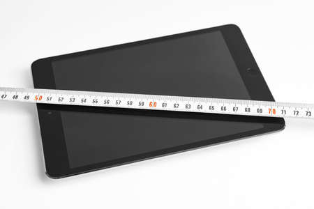 Tablet and tape measure. Isolated on white. Construction design. Horizontal