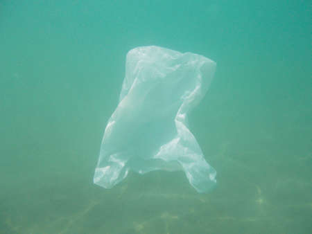 Plastic bag floating into the sea. Polluted enviromental. Recycle garbage