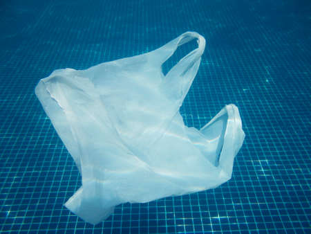 Plastic bag floating into the water. Polluted enviromental. Recycle garbage
