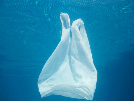 Plastic bag floating into the water. Polluted enviromental. Recycle garbageの写真素材