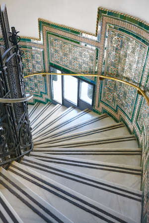 Antique decorated spiral stairway with marble steps. Classic building interior