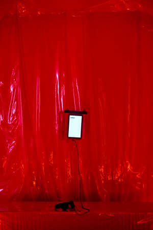 Listening streaming music with a tablet and headphones. Red interiorの写真素材