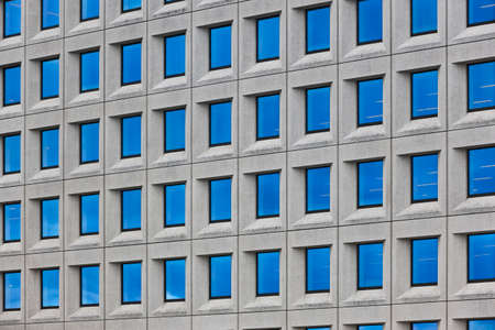 Modern concrete building facade with geometric windows. Contemporary minimalism architecture