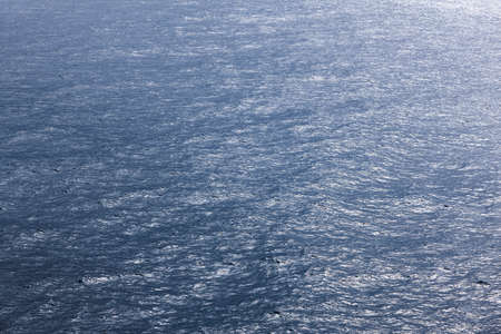Blue surface ocean background with soft waves. Tide seascape. Infinity 