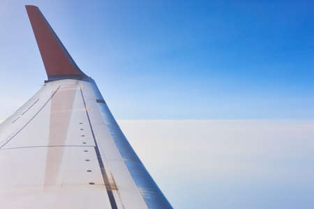 Aeroplane wing over a blue sky background. Fly transport