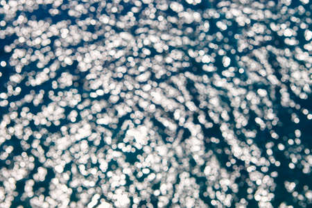 White reflections on the water. Out of focus reflected lights
