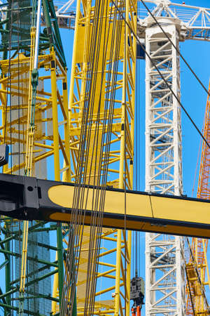 Telescopic cranes under a blue sky. Construction engineering industry