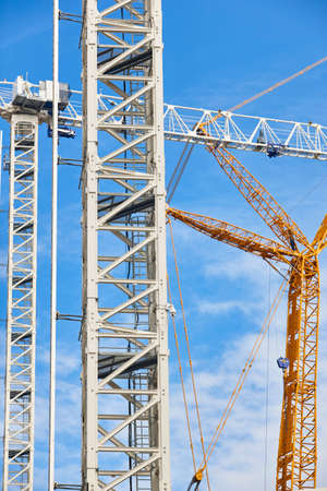 Telescopic cranes under a blue sky. Construction engineering industryの写真素材