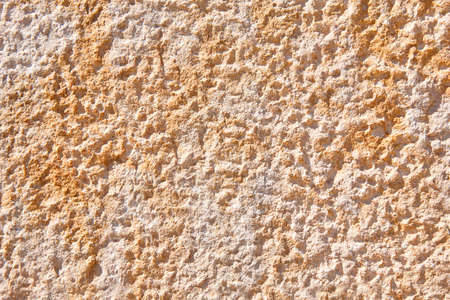 Textured warm tone stone wall background. Rough surface. Copy space