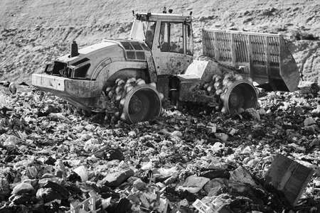 Heavy machinery shredding garbage in an open air landfill. Wasteの写真素材