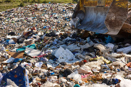 Heavy machinery shredding garbage in an open air landfill. Wasteの写真素材