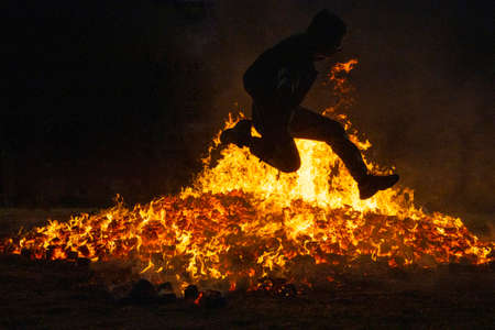 Summer solstice celebration jumping into the fire. Burning flames. Dangerの写真素材