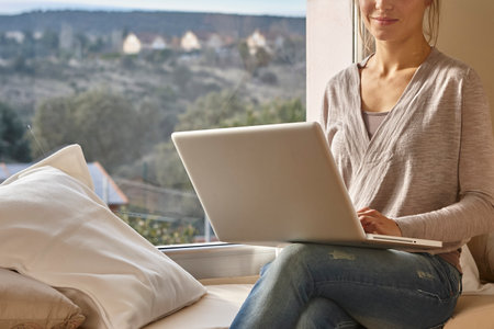 Young woman surfing the internet at home. Modern lifestyle. Studentの写真素材