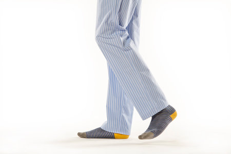 Man wearing a pajama. Legs detail over a white backgroundの写真素材