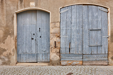 Rustic wooden doors on blue tone. Rural aged facade buildingの写真素材