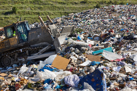 Heavy machinery shredding garbage in an open air landfill. Wasteの写真素材