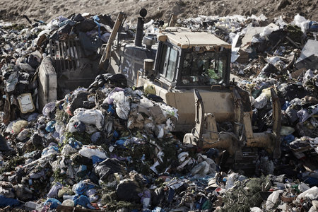 Heavy machinery shredding garbage in an open air landfill. Wasteの写真素材
