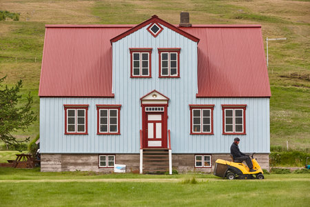 Icelandic gardener working in his cottage with lawn mower. Icelandの写真素材